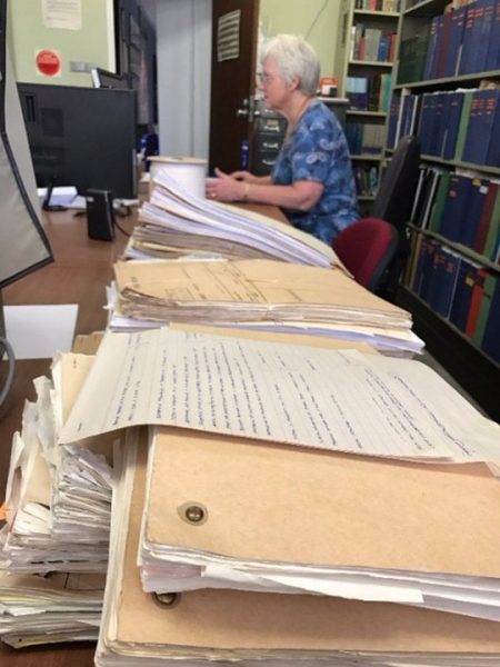 Carol working her way through scads of old paperwork. Image Credit: Julie Matthews