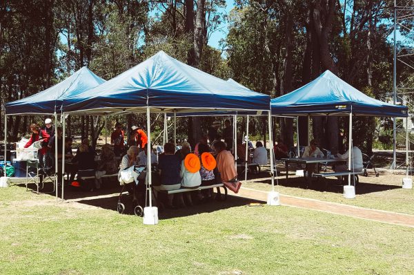 Day tour group having lunch under marquees. Image Credit: Matt Woods