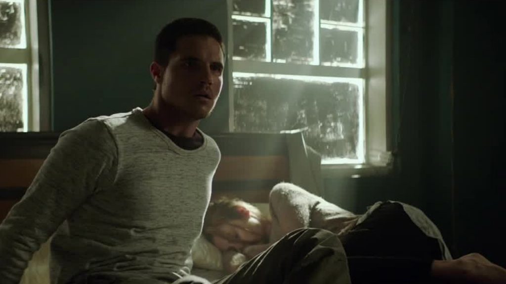 Robbie Amell as Renton waking up beside his former lover, Hannah. Image Credit: Netflix