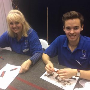 Volunteers Julie and Jacob Matthews showing kids magnetic fields. Image Credit: Michelle Ashley Emile