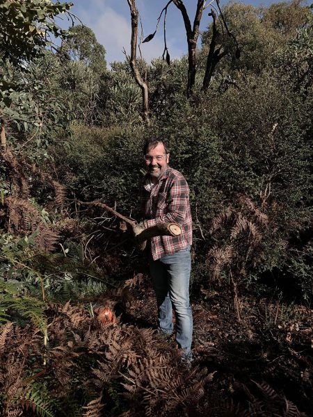 Steve is way too happy that he has control of a chainsaw. Image Credit: Julie Matthews