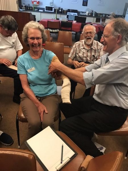 Chris very happy to have Matt immobilising her 'broken arm', Terry is happy that he's not being bandaged. Image credit: Roger Groom